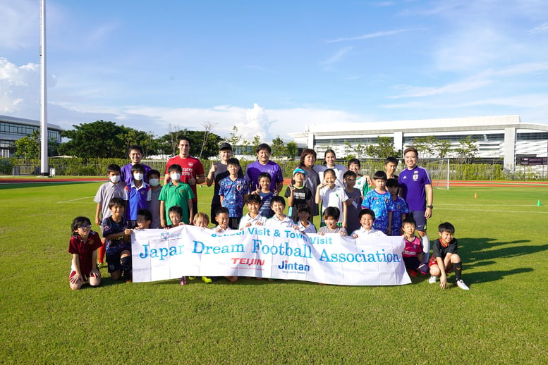 Masao Kiba(center) with Sami Yosef, VERSO Admissions Director (second left) Eakgapon Poyprakon, Sports Development Manager, VERSO (extreme right) with some of the players an an exclusive soccer skills clinic held at VERSO International-min